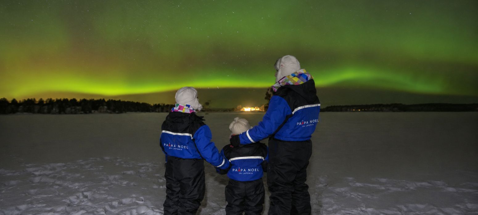 Familia contemplando una aurora boreal en Laponia